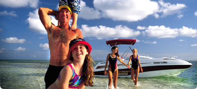 Family on beach with a boat in the background